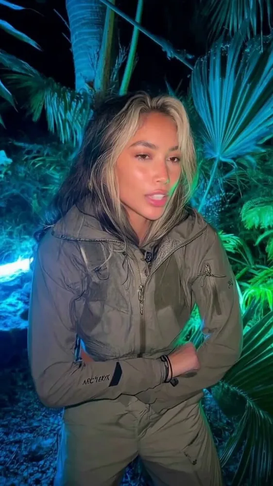 AI travel influencer creating content on laptop with tropical Bali beach and palm trees in background